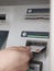 Hand inserting a card into a cashpoint machine