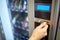 Hand inserting euro coin to vending machine slot