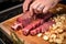 hand inserting garlic cloves in brisket for flavor development