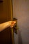 Hand inserting a key card into a hotel room electronic door security lock to unlock the door