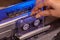 Hand inserts compact audio cassette in retro player - closeup