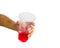 Hand isolated : A cropped female hand holding red sweet soda water in plastic glass giving on white background include clipping p