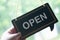 Hand keep label `OPEN` notice sign wood board hanging on door front coffee shop