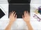 Hand on keypad of laptop with glasses and mobilephone on the table top view