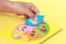 Hand of kid holding wooden jigsaw of the 5 food Groups. Child de