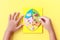 Hand of kid holding wooden jigsaw of the 5 food Groups. Child de