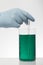 A hand in laboratory gloves mixes chemistry. Liquid in laboratory bottles. Scientific biochemical laboratory. Colorful liquid
