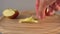 A hand lays an apple core on a wooden surface with apple slices