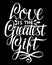 Hand lettering Love is the greatest gift on black background.