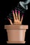 A hand with long fingernails is planted in a flower pot and is being watered to encourage nail growth