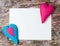 Hand made felt colorful hearts white paper on wooden background