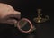 Hand with a magnifying glass while examining antique items.