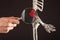 Hand with magnifying glass over elbow bones of human skeleton with red point. Humerus, radius, ulna. Arm pain caused by