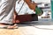 Hand of a male laborer who is a laborer In his hand held a metal cutter The iron is being cut outdoors. To prepare for repairs He