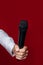 the hand of a male reporter, journalist holds a microphone on a red background