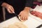 hand of man cutting panini italian sandwich