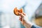 Hand of a man holding a bitten sandwich