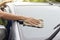 Hand of a man holding a cloth wipe car windscreen.