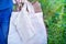 Hand of man holding eco friendly white cloth (canvas fabric) bags and paper bag for organic shopping. Nature green