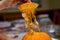 Hand of a Man Lifts the Top Cap Off of a Cut Pumpkin Ready to Sc