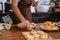 Hand of a man making homemade donut on wooden table