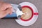 Hand of a man pouring milk into black coffee