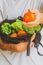 Hand of a Man showing a tomato and holding a cotton mesh bag reusable full of eco vegetables on the background. Eco friendly