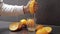 Hand of man squeeze juice from an orange into glass. Man hold half of orange on hand