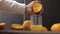 Hand of man squeeze juice from an orange into glass. Man hold half of orange on hand