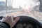 Hand of a man on the steering wheel of a car that is driving on a slippery road