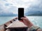 Hand of man using mobile smart phone against scenic landscape of boat view in the big river and reservoir dam with mountain and
