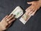 hand of man and woman exchanging russian banknotes and american dollars bills