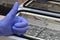 The hand of a manicurist in a blue medical glove shows a thumb up