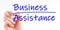 A hand with a marker writing `business assistance