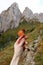 Hand with meadow flower in mountains. Great hiking spot