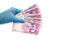 A hand in a medical glove holds Ukraine state money, hryvnia, on a white background isolated. Paid service concept