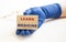 A hand in a medical glove holds wooden cubes with the inscription LEARN MEDICINE