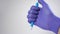 A hand in a medical glove presses the button of a plastic automatic ballpoint pen