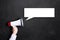 Hand with a megaphone in front of a blackboard