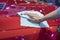 Hand with microfiber cloth cleaning car