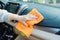 Hand with microfiber cloth cleaning seat, auto detailing and valeting concept, washing car care interior, selective focus