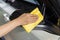 Hand with microfiber cloth cleaning side mirrors of car