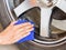 Hand with microfiber cloth cleaning wheel