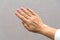 Hand of a middle-aged woman on a gray background. Large bulging veins on the female hand