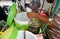 Hand are mixing Cendol with coconut milk , Indonesia desserts called Cendol