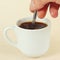 Hand mixing with spoon of prepared coffee in the cup