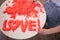 Hand molded of red kinetic sand the word love