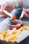 Hand Mother and daughter holding serrated french fries dip to tomato sauce