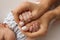 The hand of a mother and father close-up holds the fist of a newborn baby.