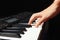 Hand of musician play the keys of the digital piano on black background